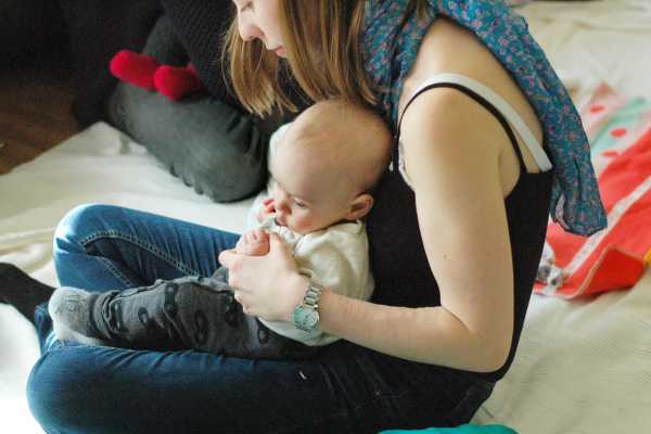 Mutter am Boden sitzend mit Kind am Schoß